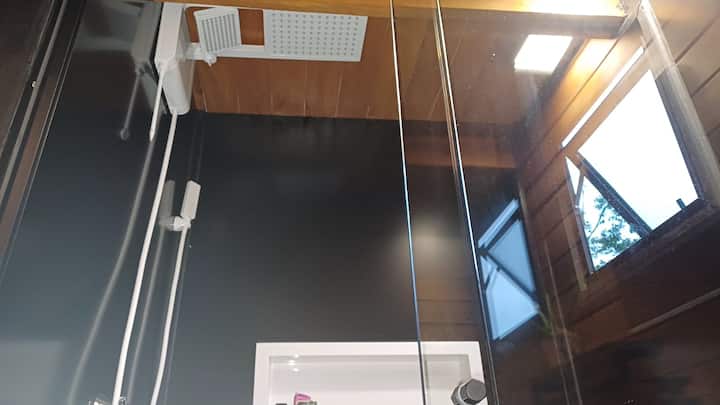 Varanda externa da cabana com guarda-sol e mesa